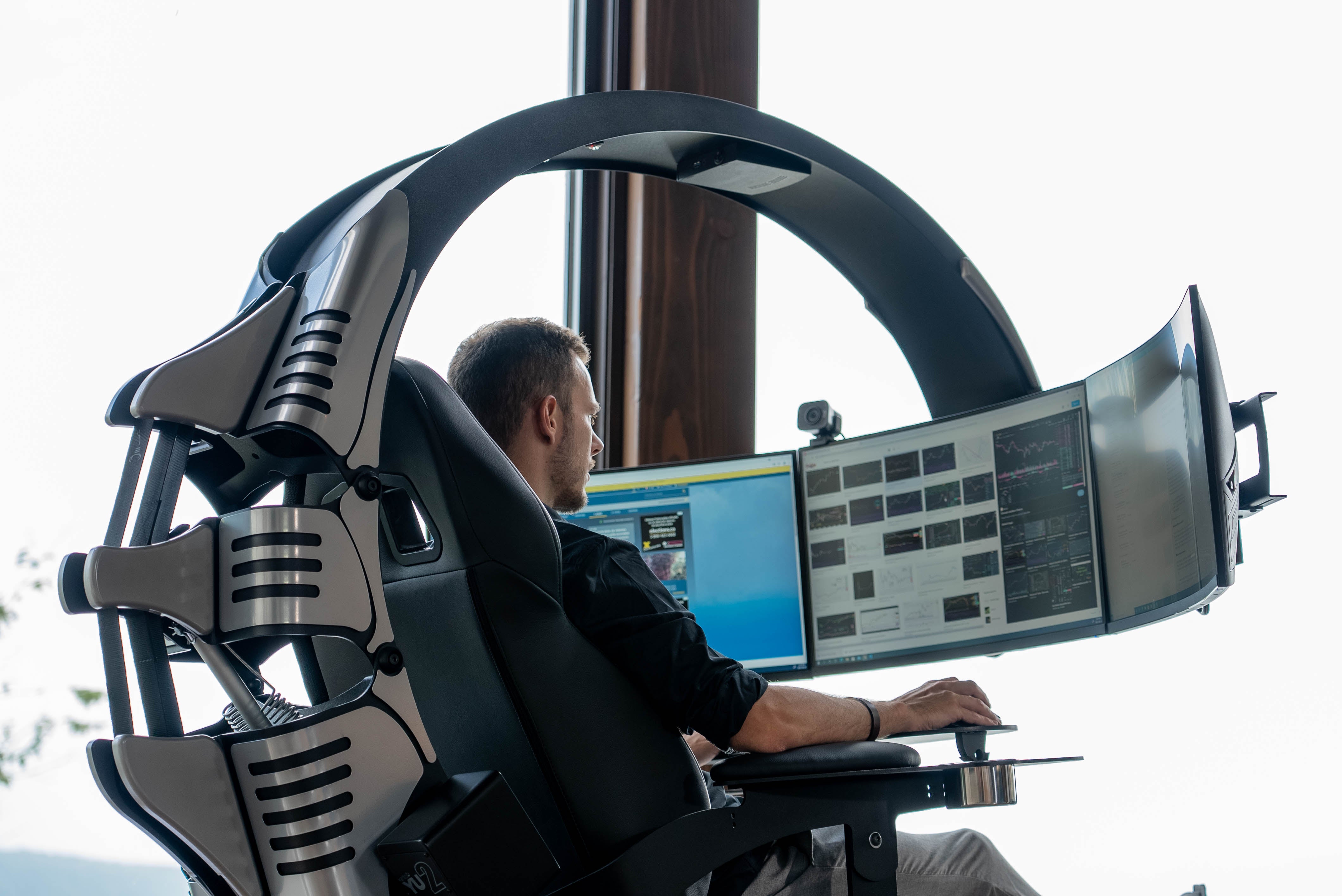 An male individual working from home in a scorpion-shaped workstation also known as the Emperor XT